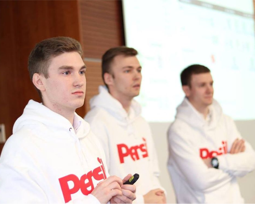 ثلاثة موظفين لدى Henkel يرتدون كنزة Persil ويقدّمون عرضًا تقديميًا